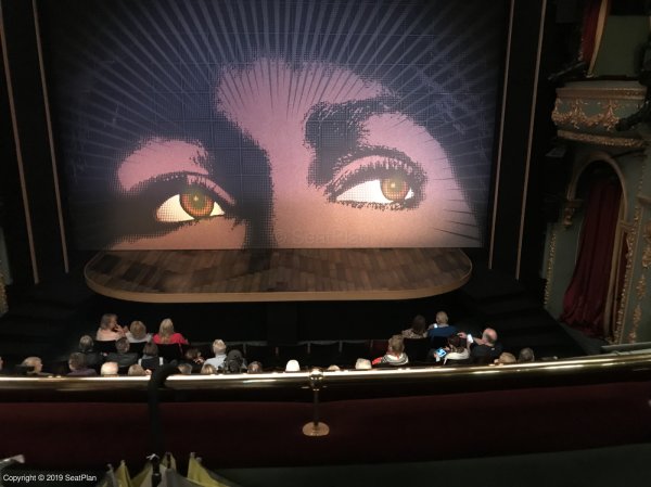 Seat view photo for the Tina Turner Musical from Dress Circle B13. The photo is of the stage from the perspective of the audience member. The stage, with curtain down, and a safety bar in front, is visible. The view is very clear.